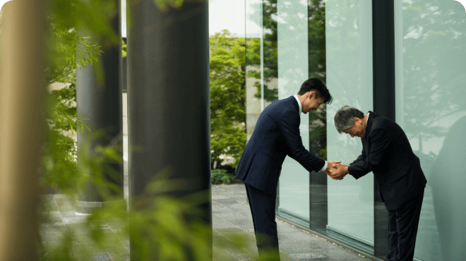 Two men in suits shake hands