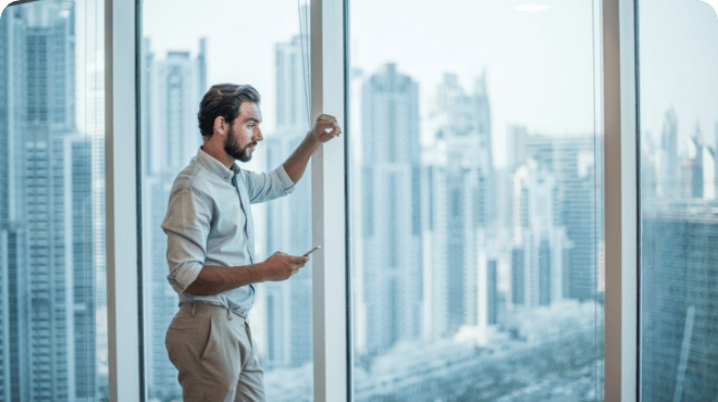 Man looks out of the window in his high-rise office building